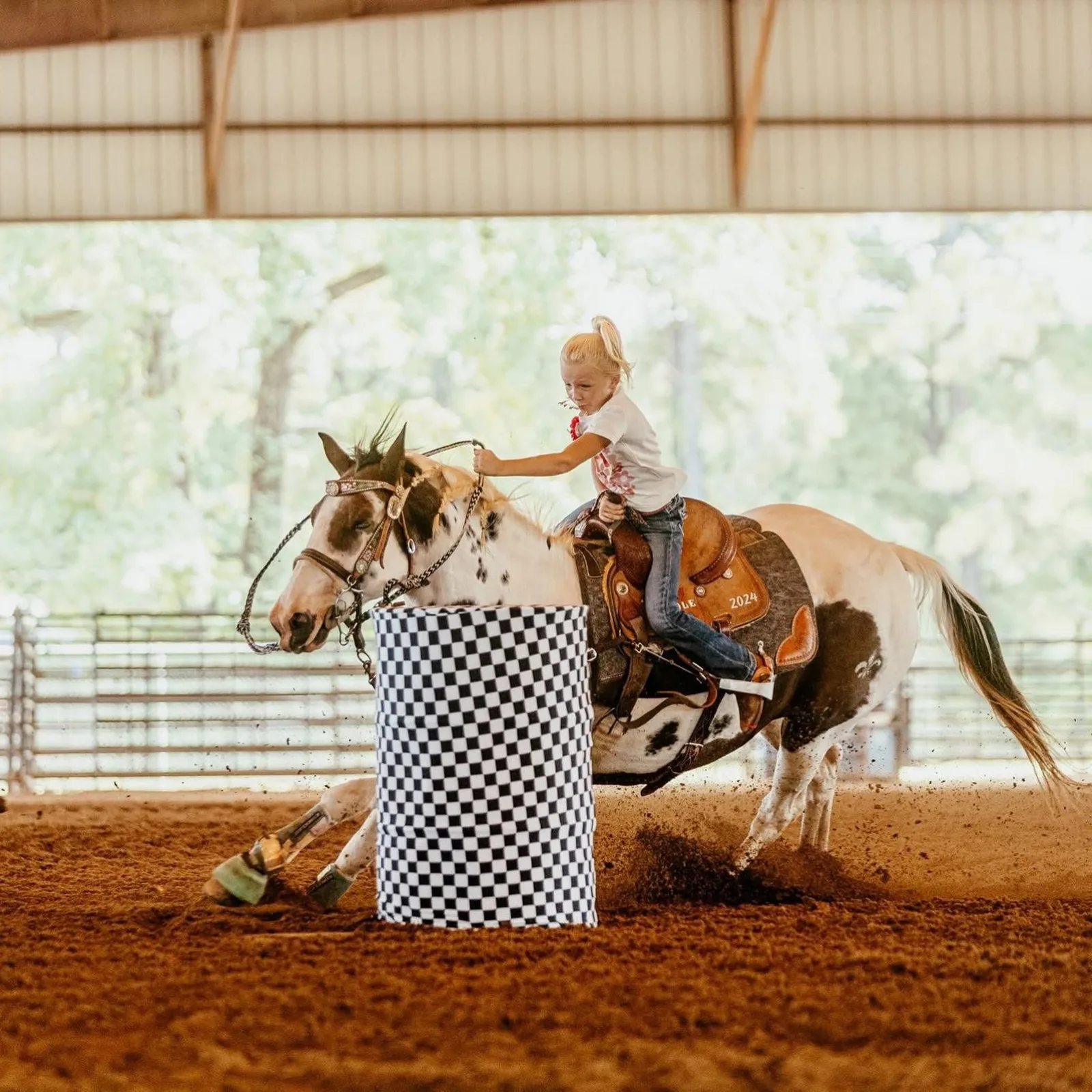 Barrel racer rounding a barrel at speed at the Sabine County Rodeo